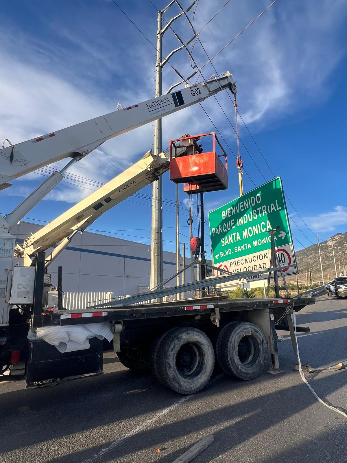 Grúa instalando letrero de bienvenida Parque Industrial Santa Mónica